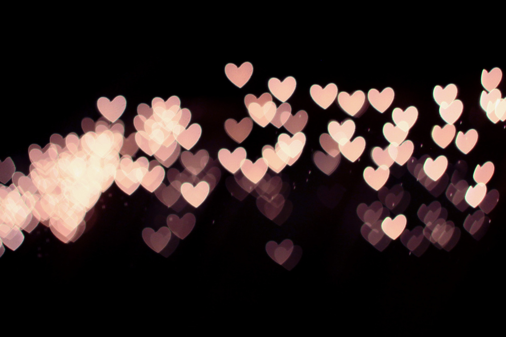 Multiple pink hearts overlapping on black background.
