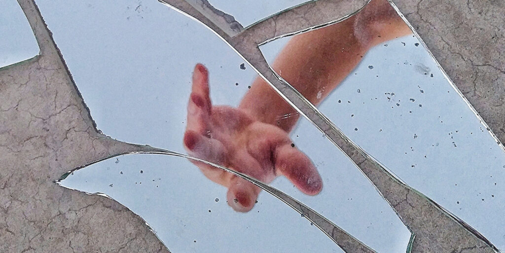 Hand over broken mirror.