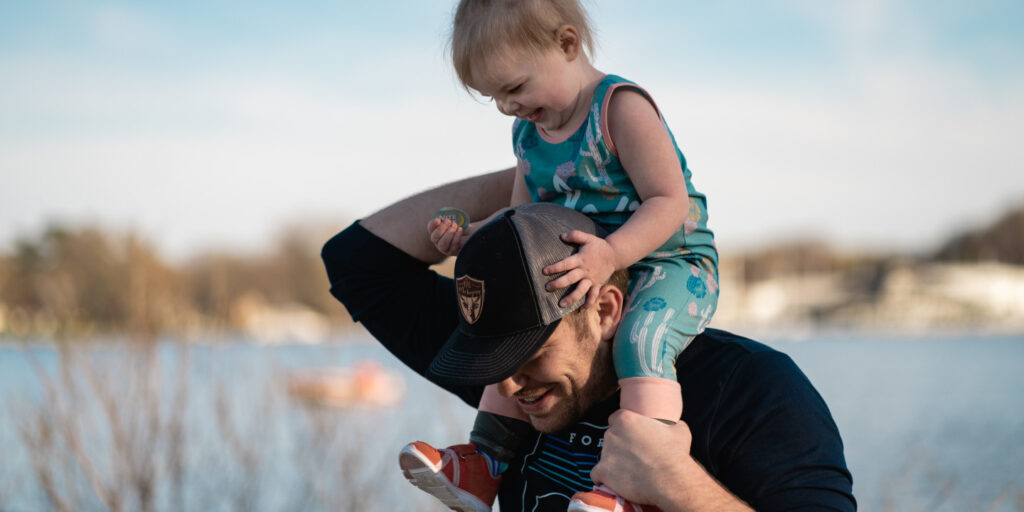 Father walking with child on shoulders.