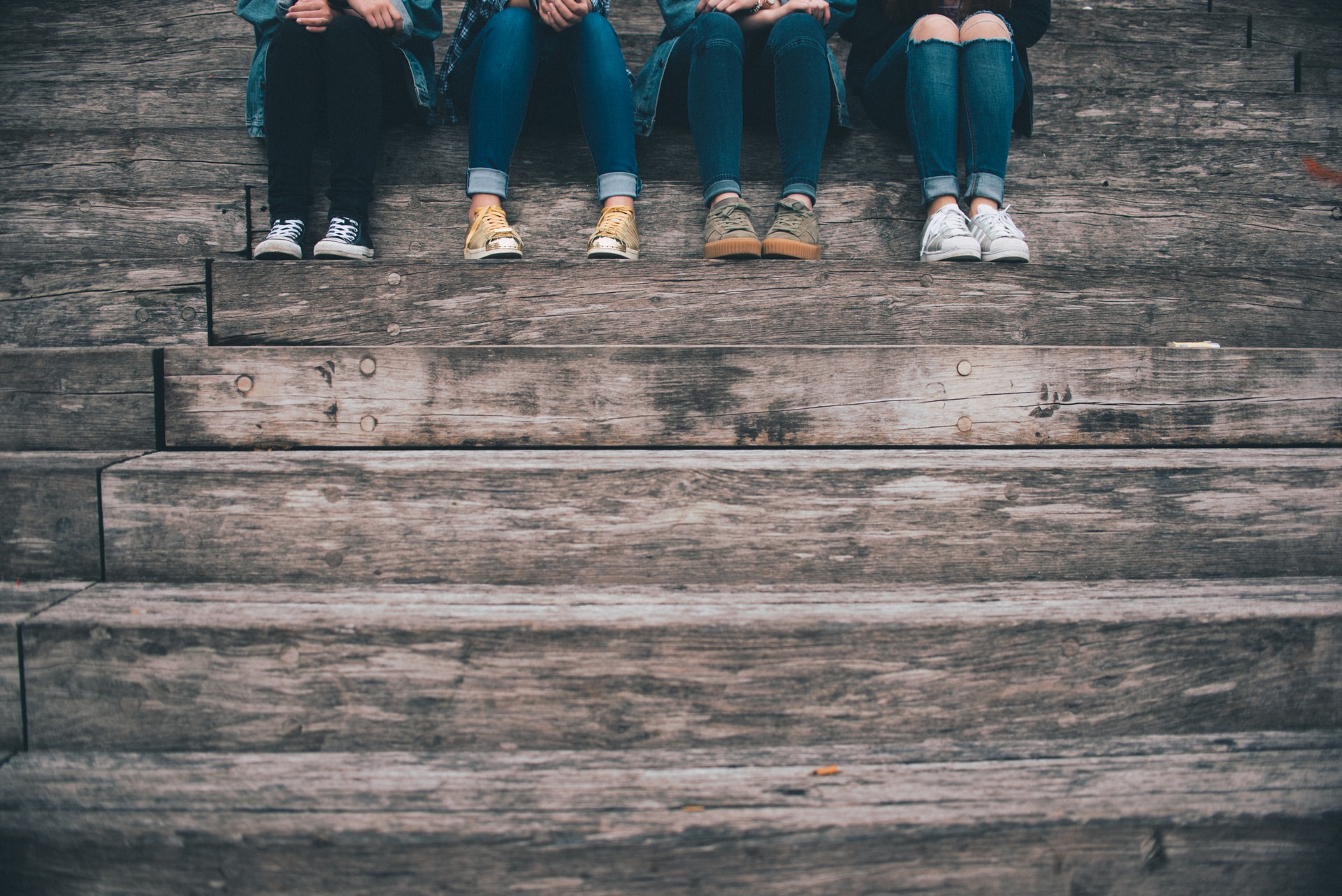 Group of 4 people sitting on stairs.