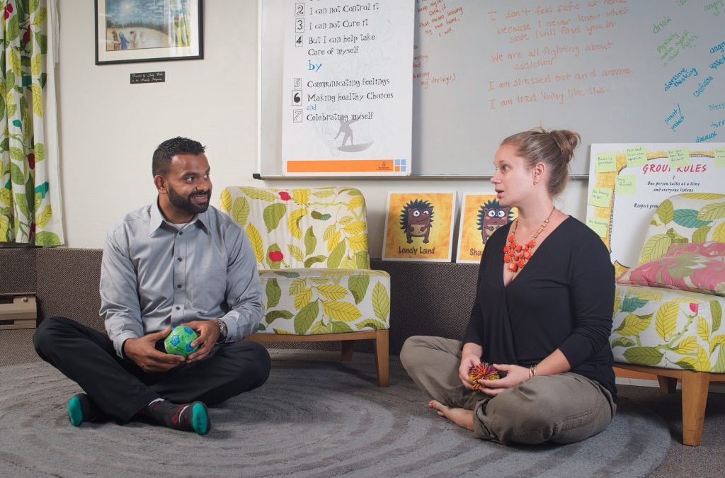 Two people sitting on the floor in the Wright Centre Family Care kids' room.