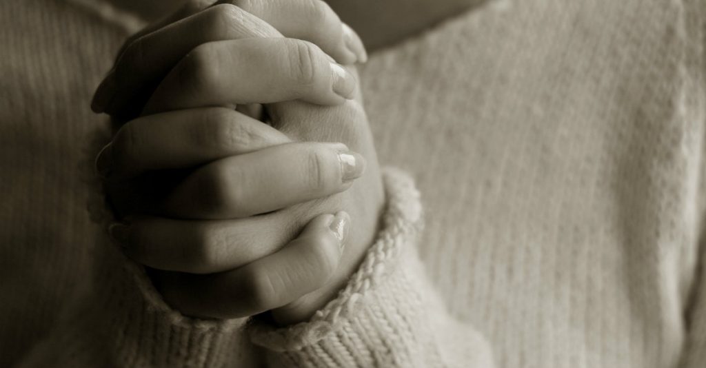 Person clasping their hands together.