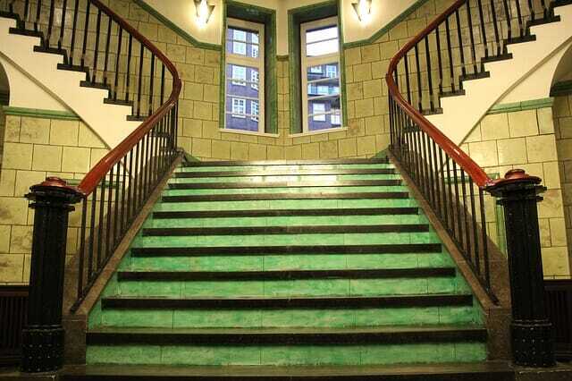 Green staircase with brown railing.
