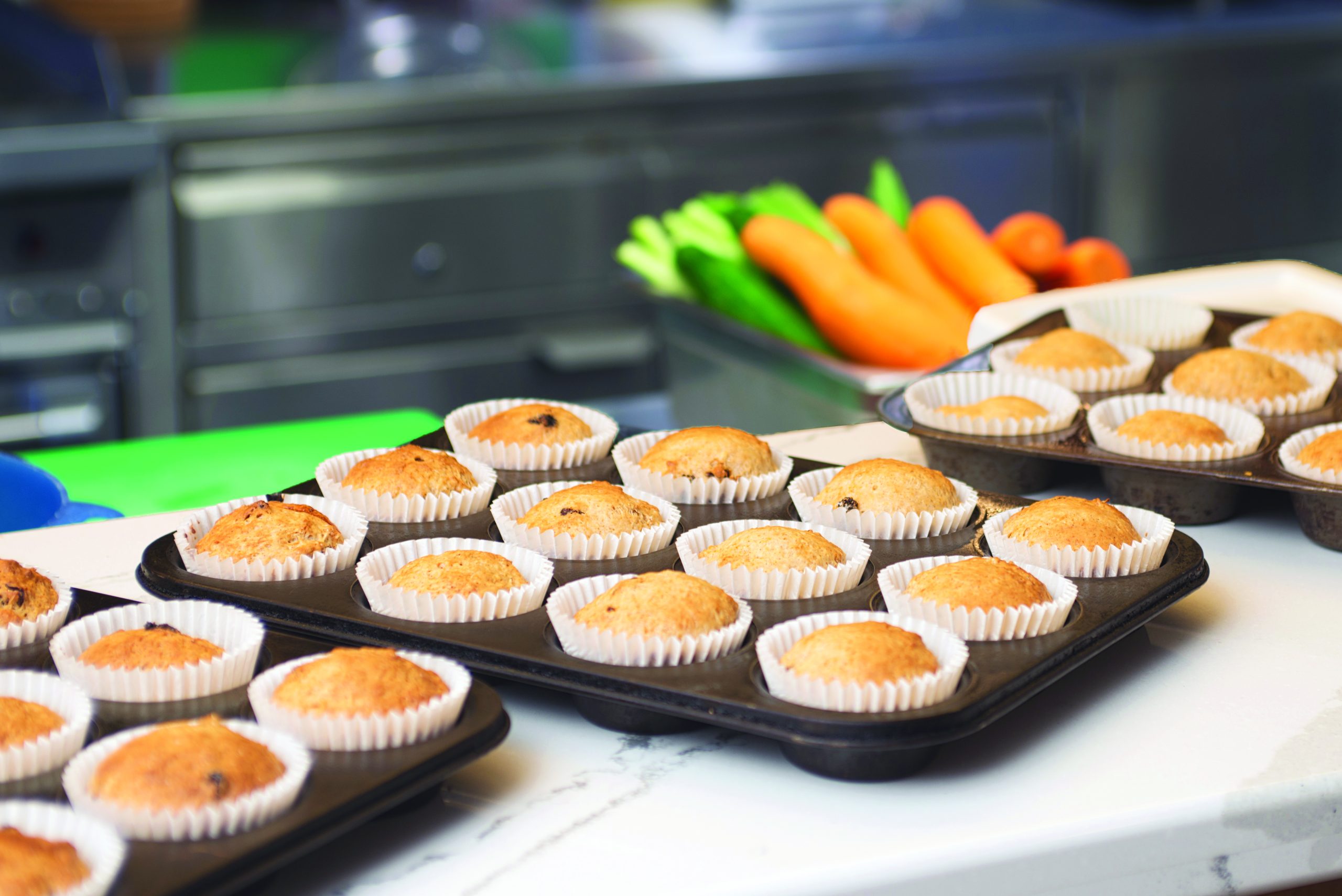 Fresh baked muffins in trays in Munro Centre kitchen.