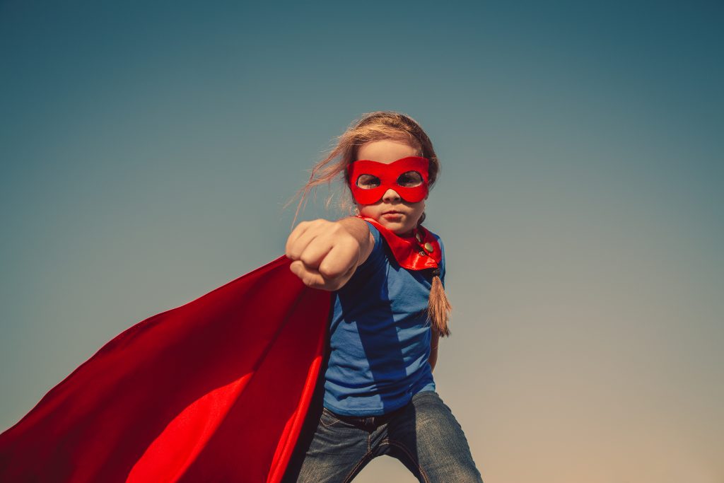 Girl dressed up in red mask and cape.
