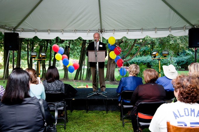 A man giving a speech to a group of people a the Sullivan Treatment Centre reopening.