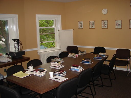 Boardroom table with books on it and chairs at Punanai Centre.