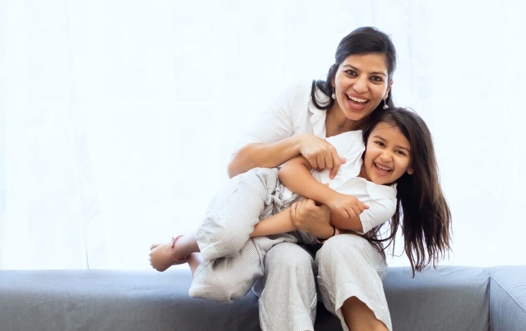 Mother and daughter cuddling and smiling for photo.
