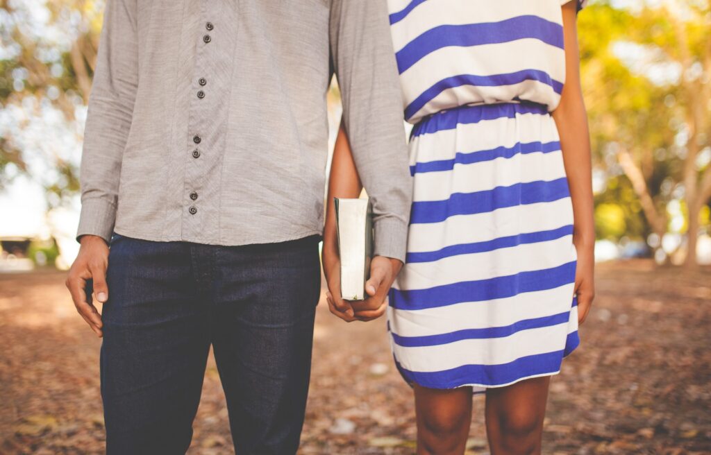 Couple holding hands with a book.