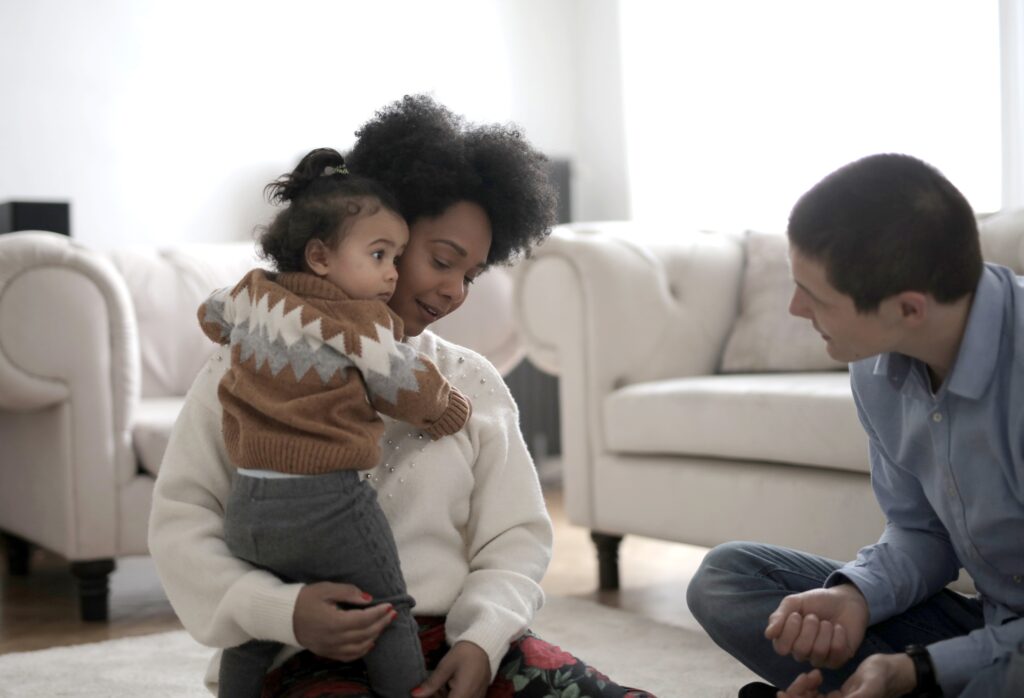 Couple sitting on floor with child.