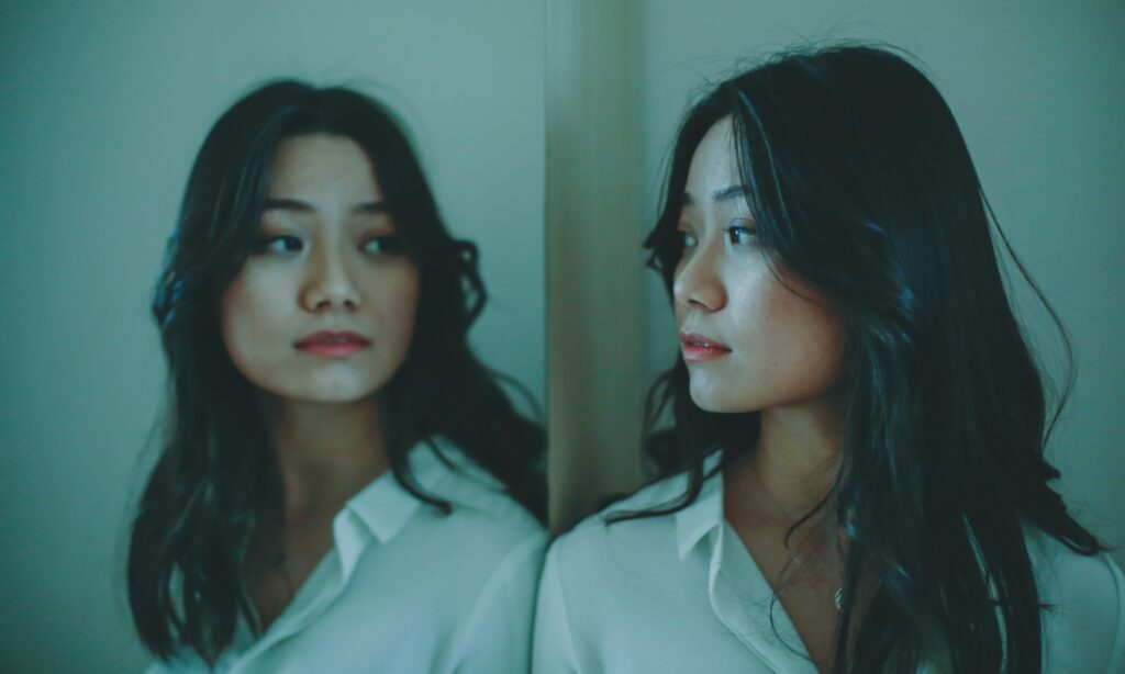 Person looking at reflection in mirror.