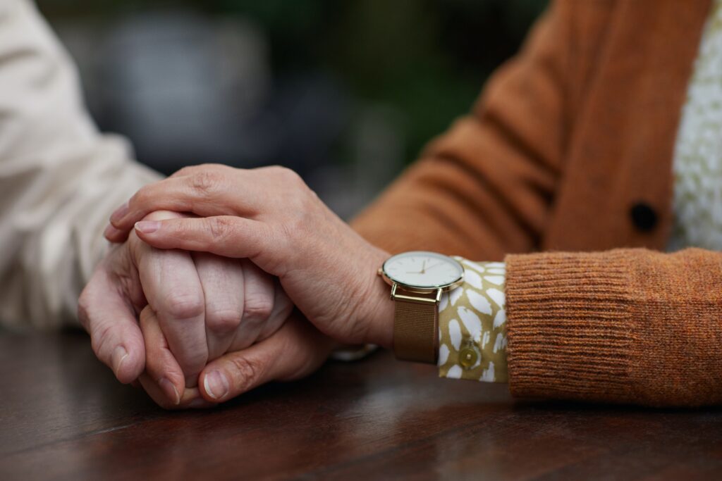 Person holding another person's hand in theirs.