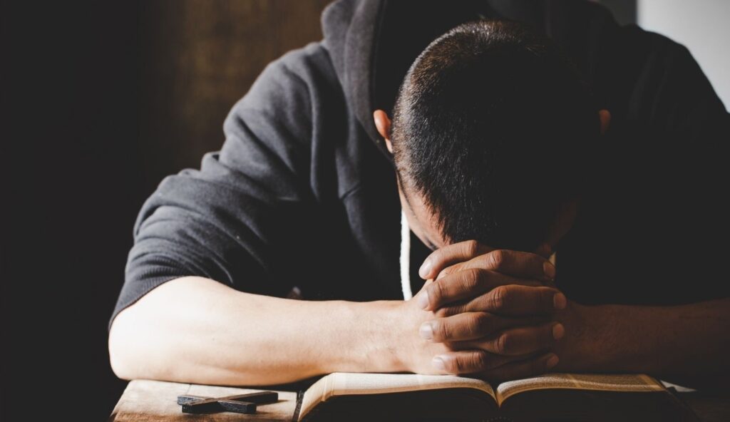Man with head down on book