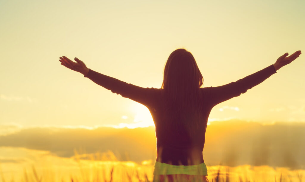 Back of person standing with arms extended out