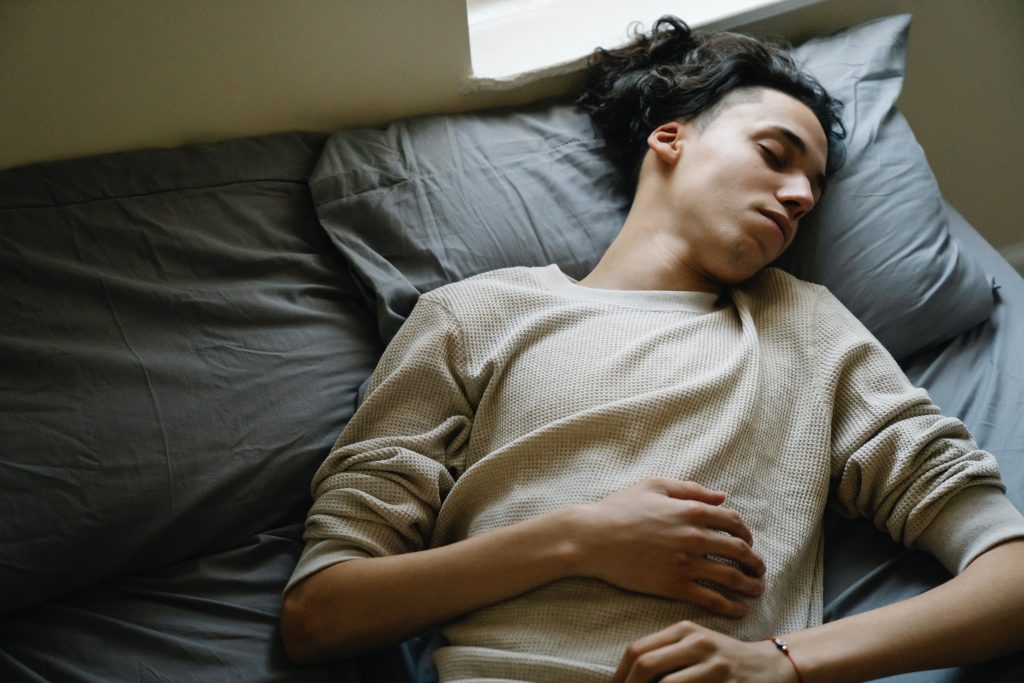 Person laying down in bed with eyes closed