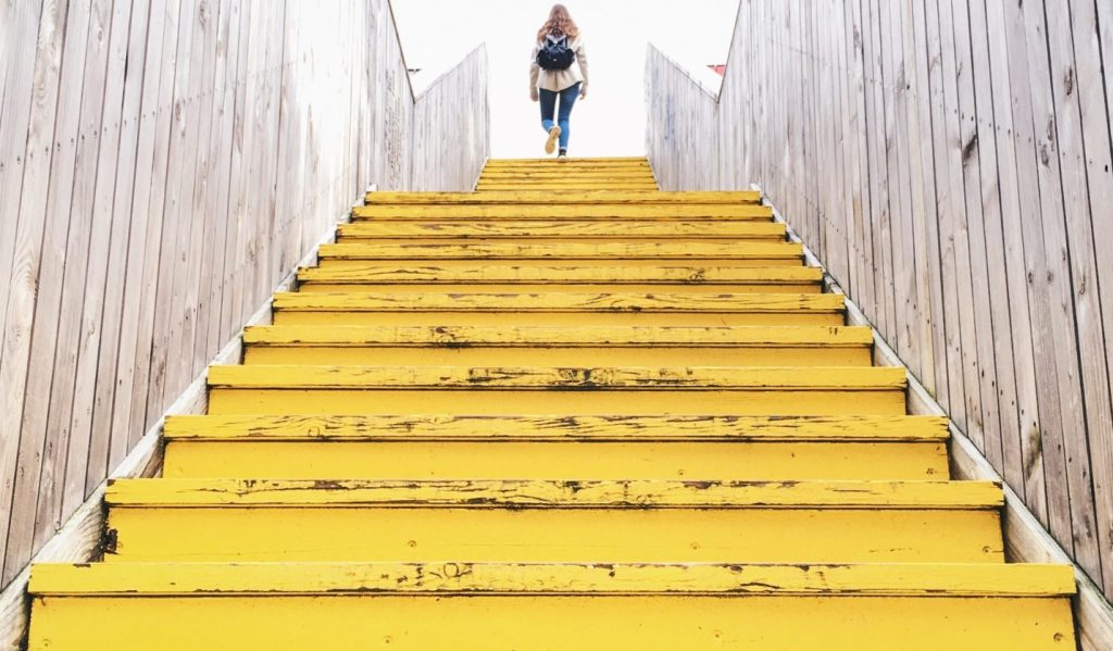 Person walking up yellow steps