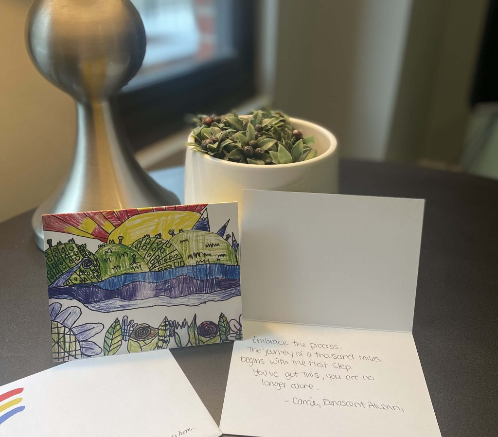 Picture of cards next to a plant on a desk