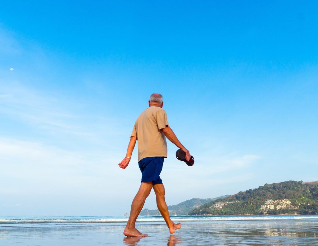 Senior walking along the beach