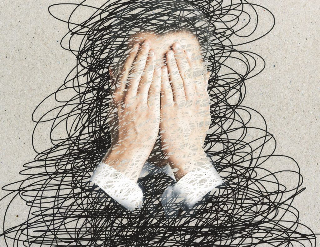 Illustration of stressed person holding hands over their eyes
