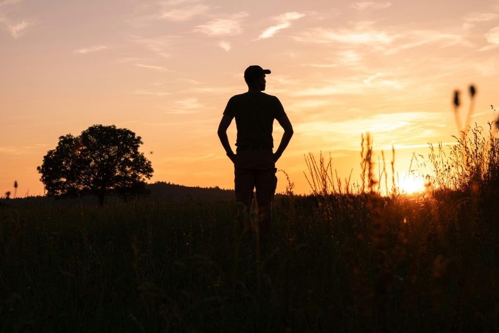 Man standing outside with sunset in the background