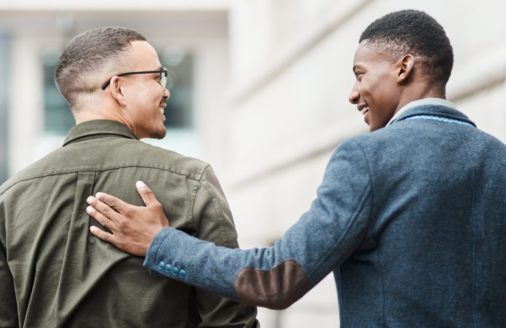Man with hand on back of another man