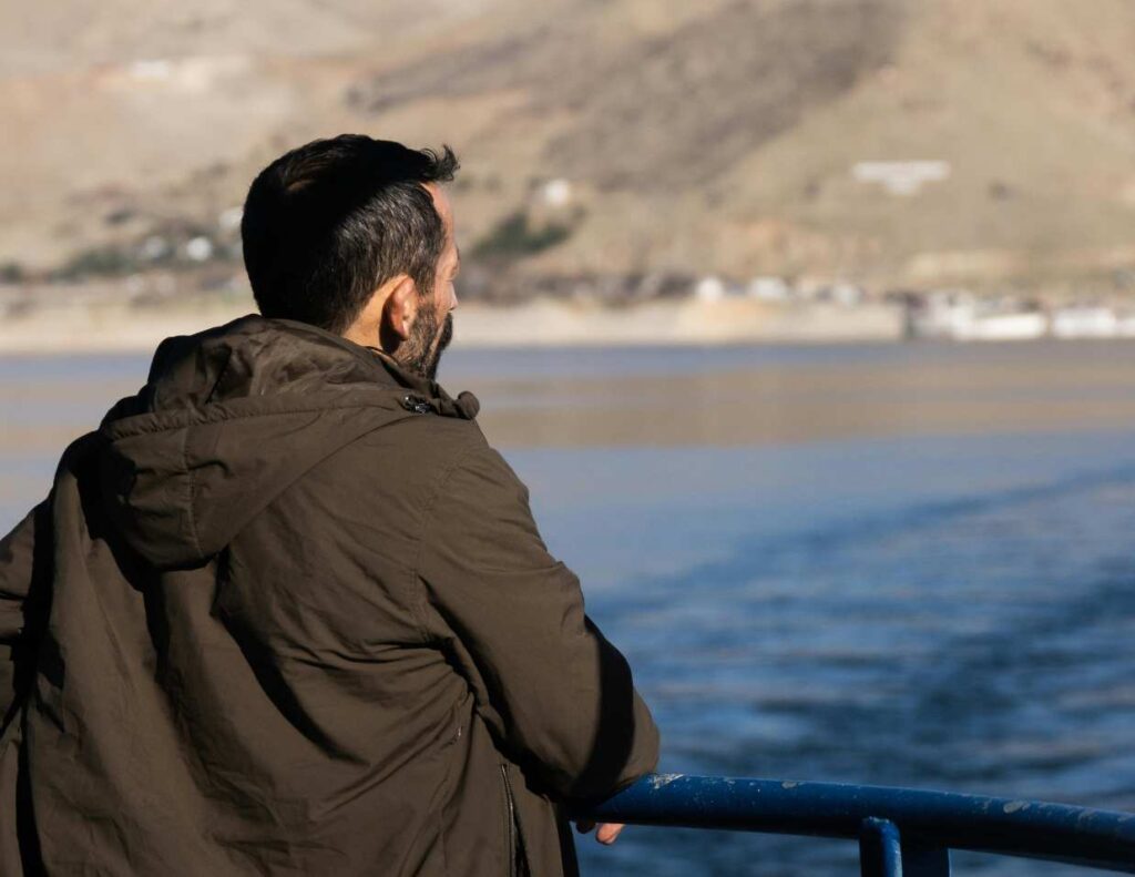 Photo of man looking out over water.